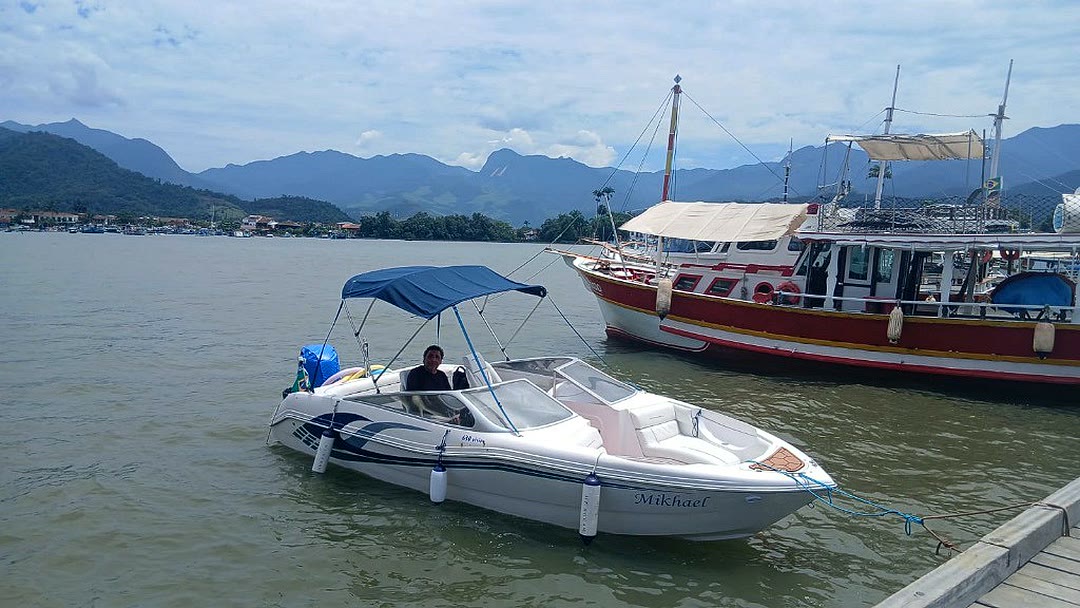 Lancha Mikhael atracada no Cais de Turismo de Paraty, com as montanhas ao fundo