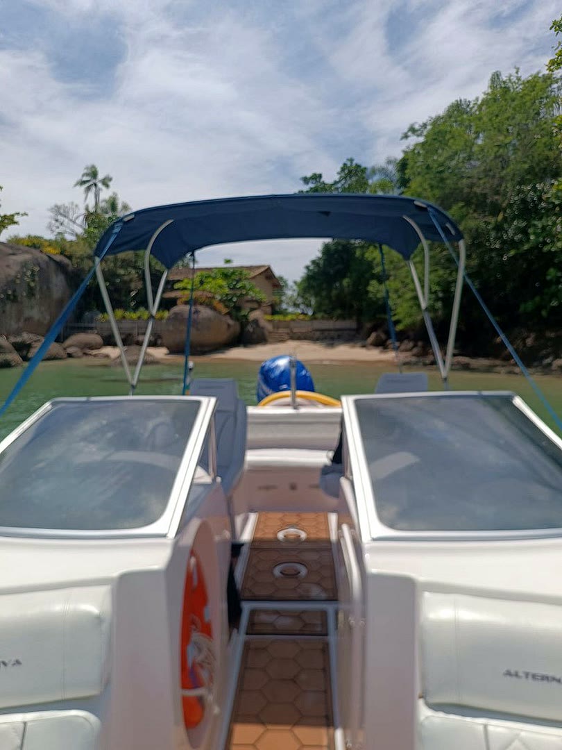 Vista da Lancha Mikhael parada em frente a uma praia de ilha em Paraty