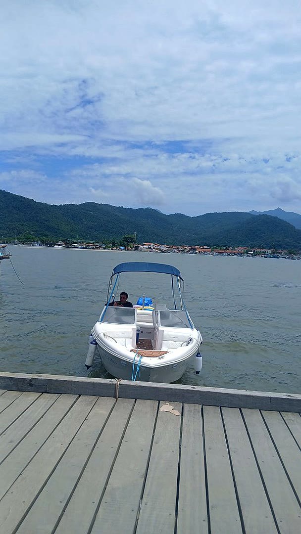 Lancha Mikhael encostada no píer de madeira em Paraty